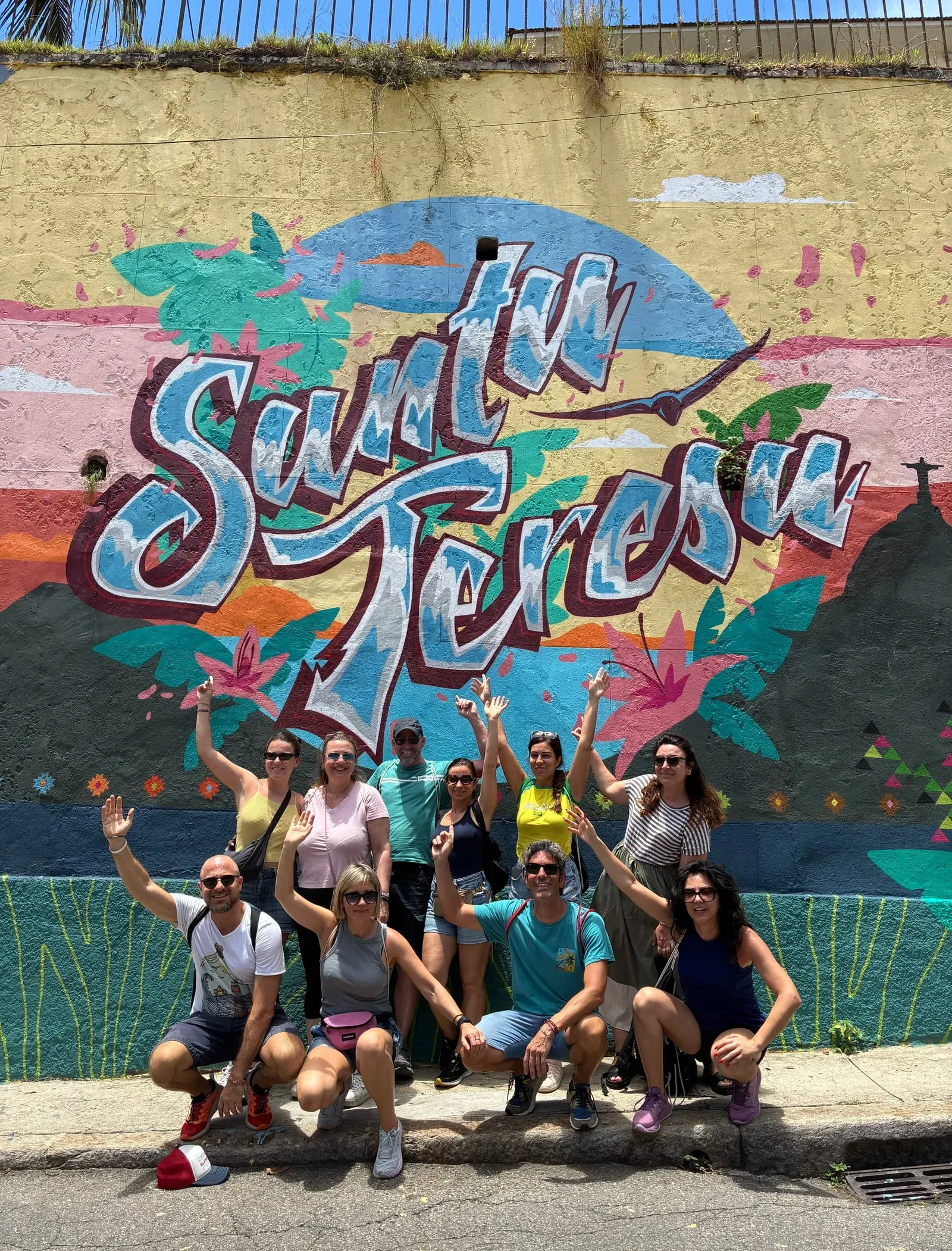Un gruppo in tour davanti al murale di Santa Teresa, a Rio